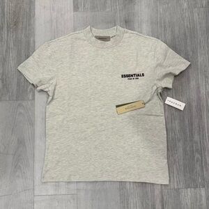 Fear of God Essentials Light Oatmeal Tee men and women both can wear